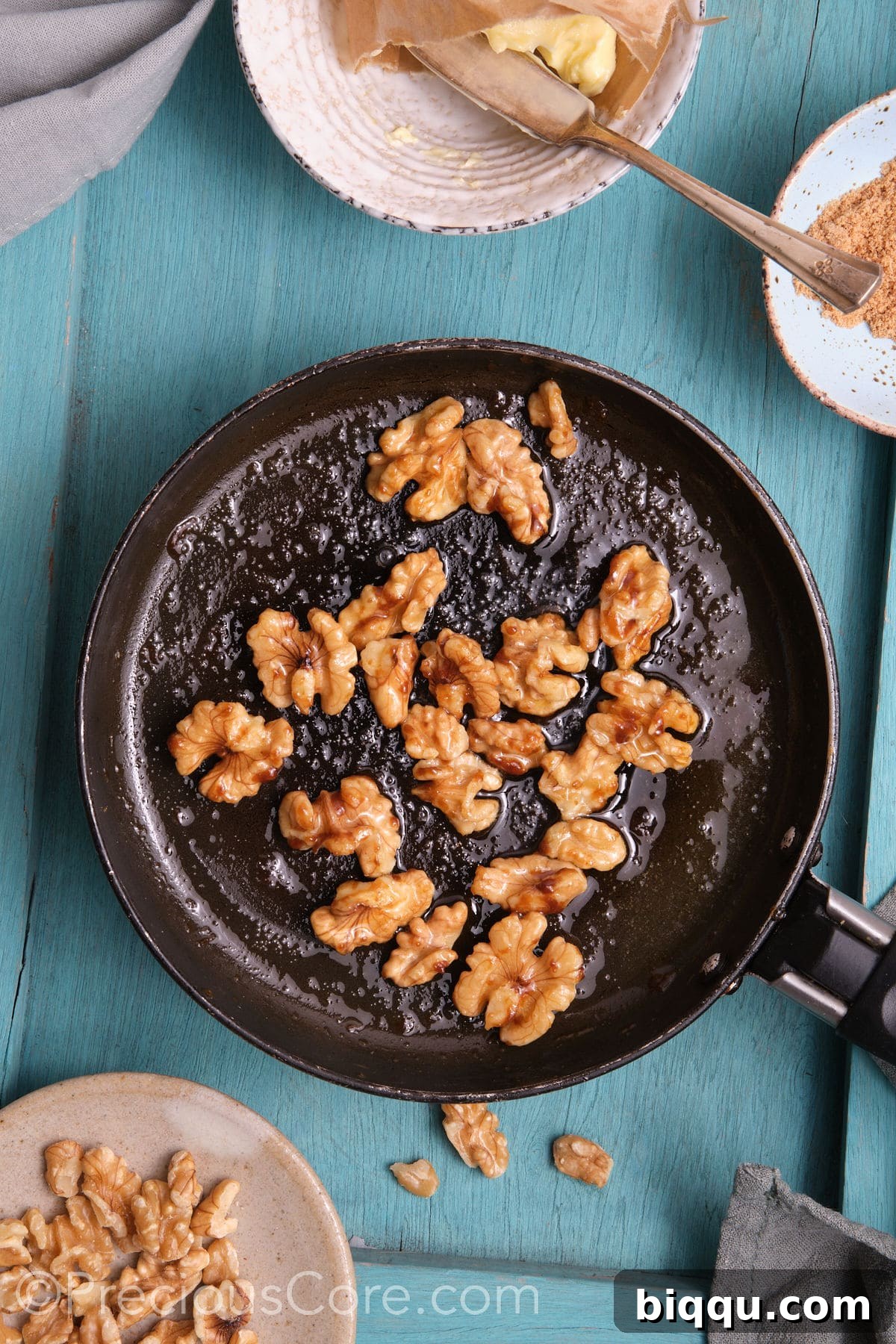 Caramelized walnuts in a small skillet.