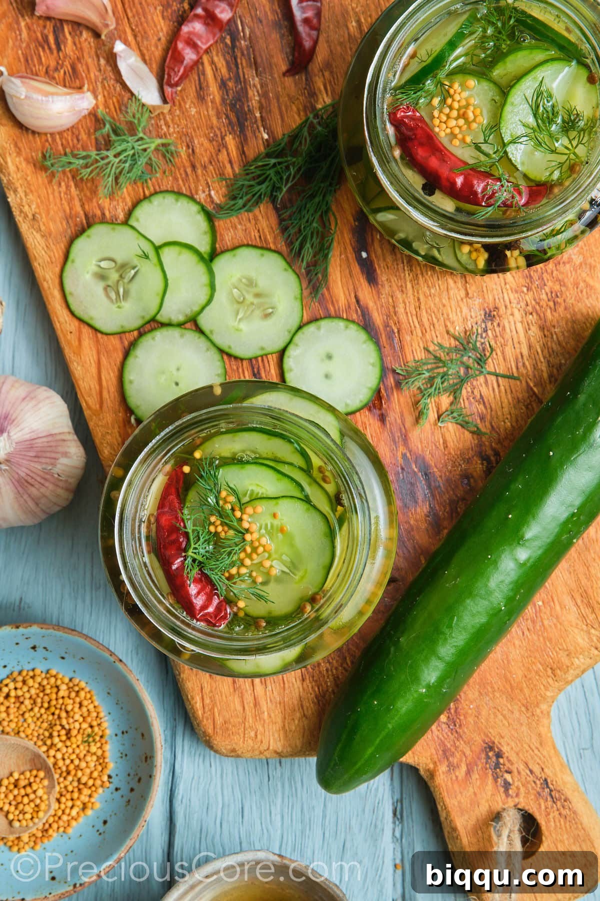 Two jars filled with pickled cucumbers.