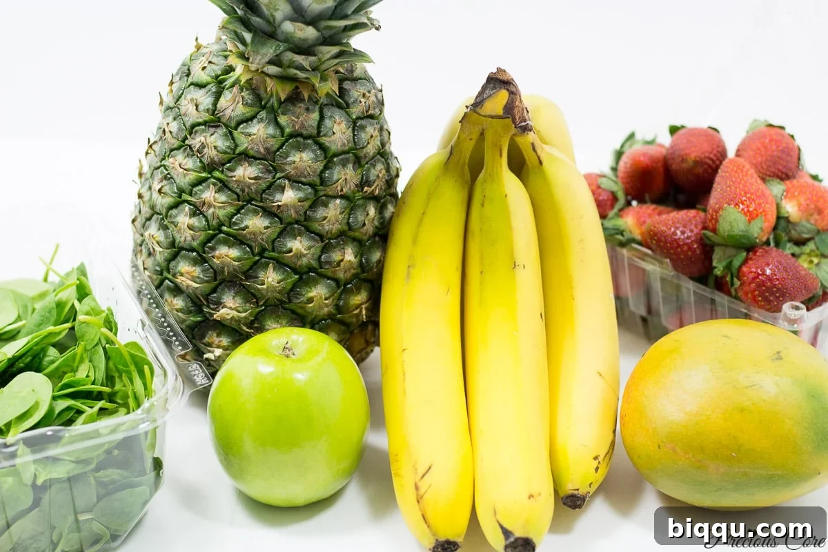 A colorful array of fresh fruits and vegetables, including pineapple, mango, strawberries, and spinach, laid out on a kitchen counter, ready for blending into delicious and healthy smoothies.