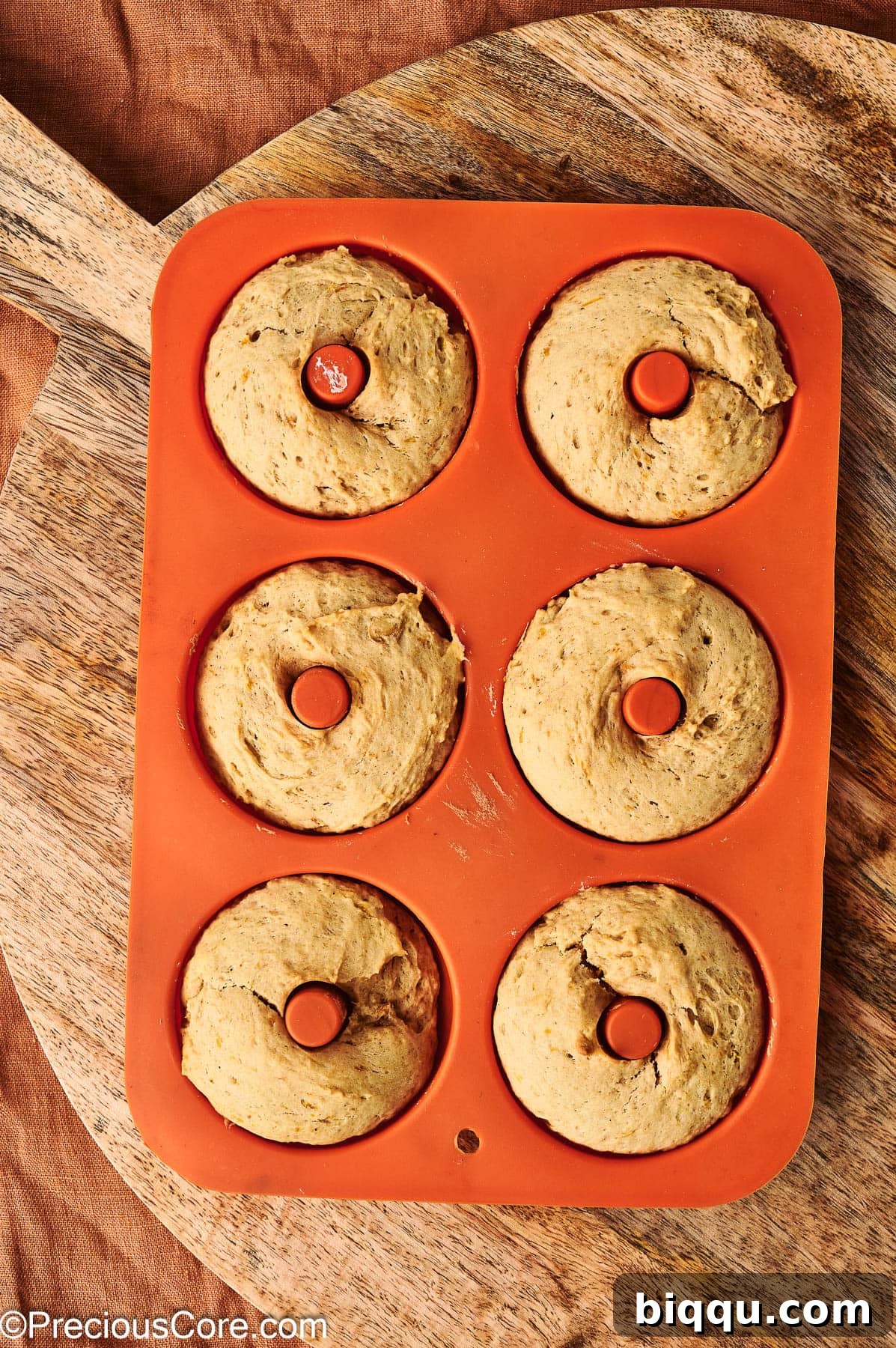 Baked pumpkin spice doughnuts in doughnut pan.