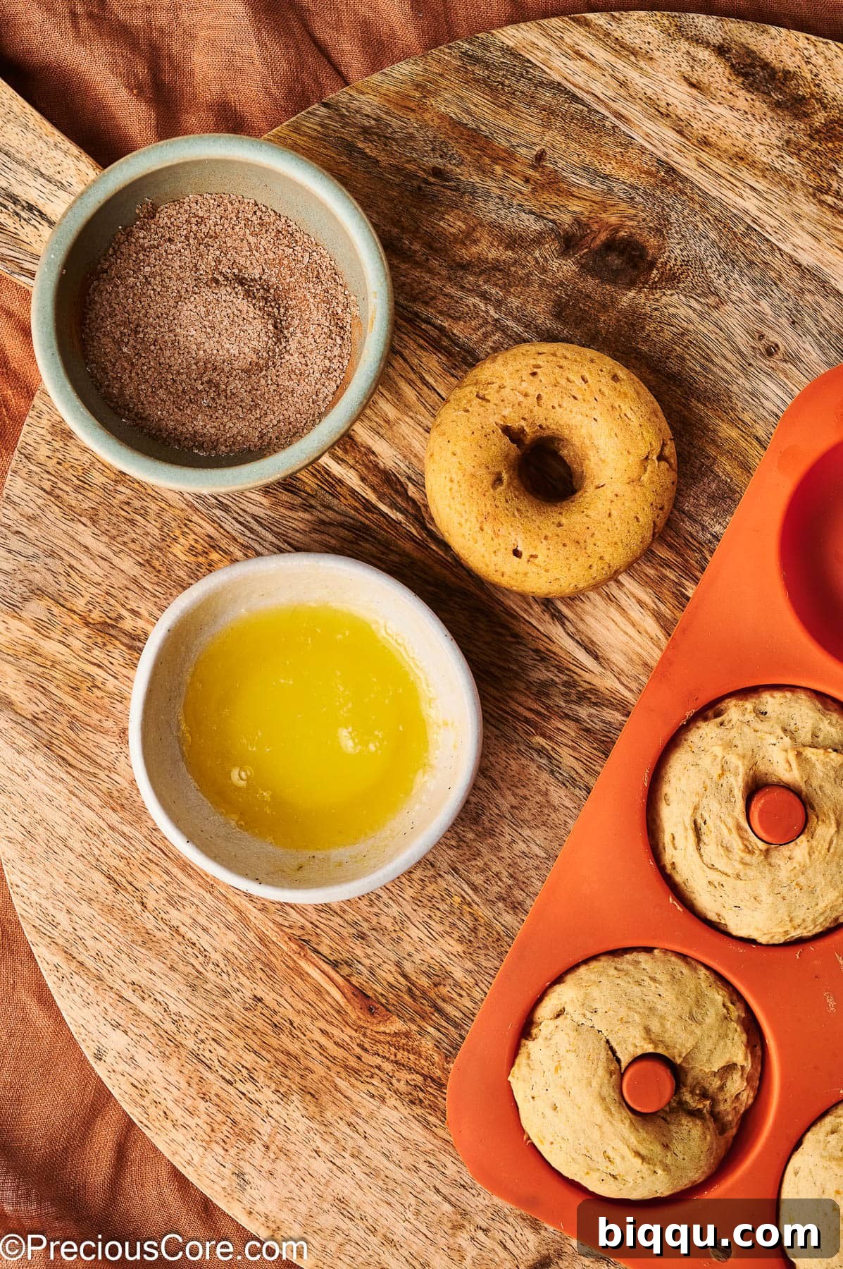 Preparing to coat doughnuts with cinnamon sugar.