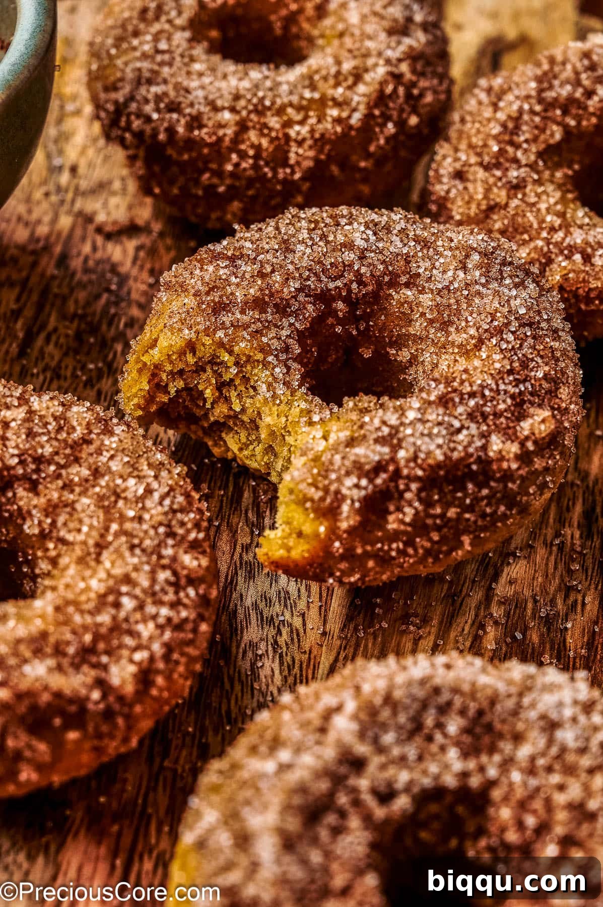 Baked pumpkin doughnuts on a wooden board.