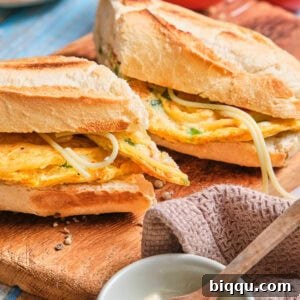 French baguette stuffed with spaghetti omelette and cut in half.