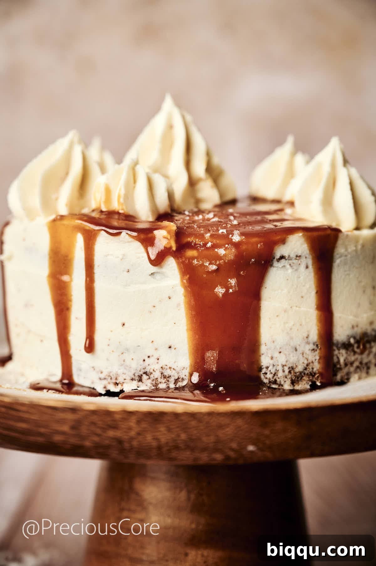 A stunning Salted Caramel Cake on a elegant cake stand, with glistening caramel artfully dripping down its sides, inviting a taste.