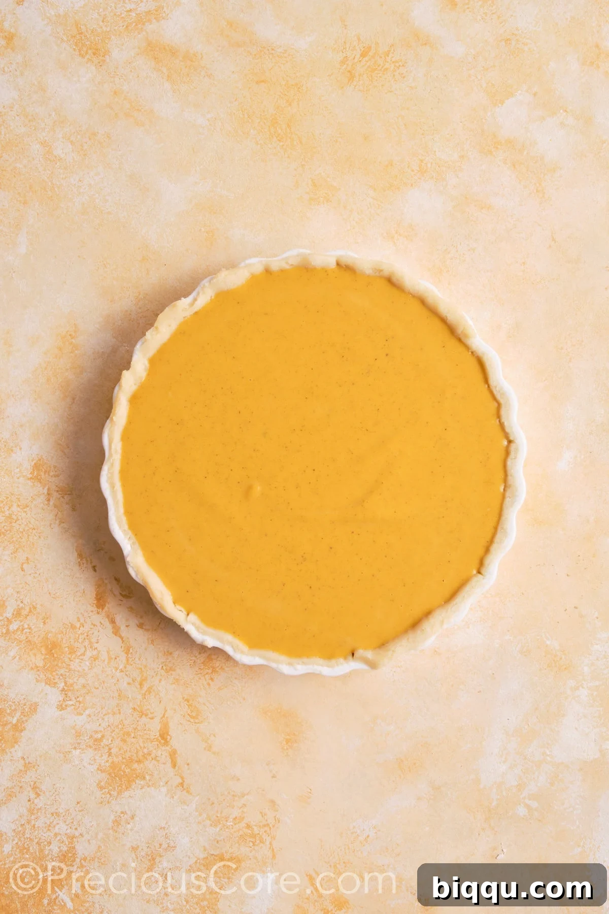 Pumpkin pie filling poured into unbaked pie crust.