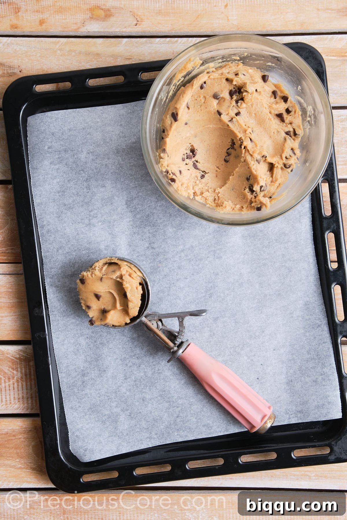 A cookie scoop filled with rich, chilled cookie dough, precisely portioned and ready to be gently placed onto a parchment-lined baking sheet.