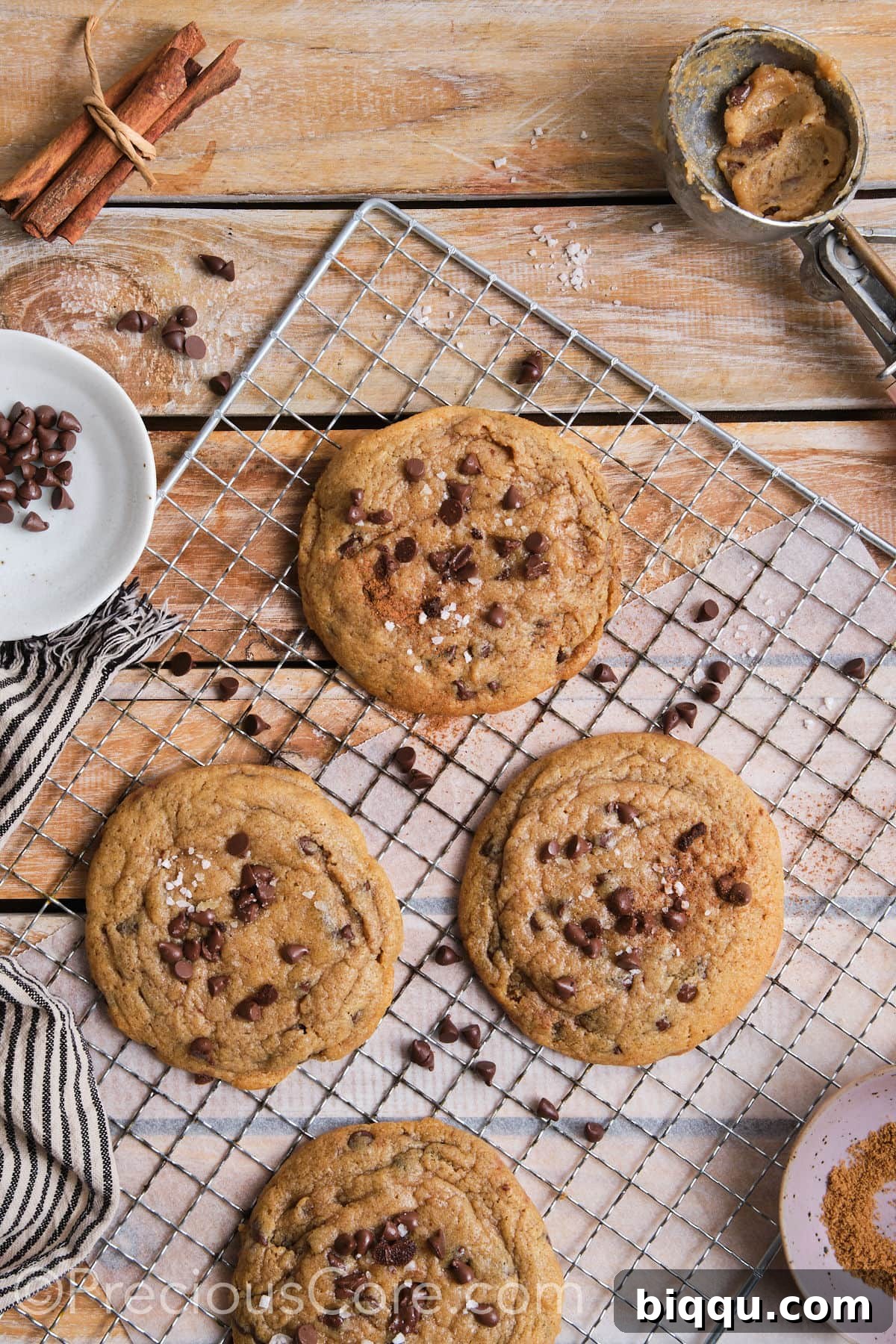 A wire rack laden with warm cinnamon and chocolate chip cookies, each artfully topped with flaky sea salt, beautifully arranged and ready to be devoured.