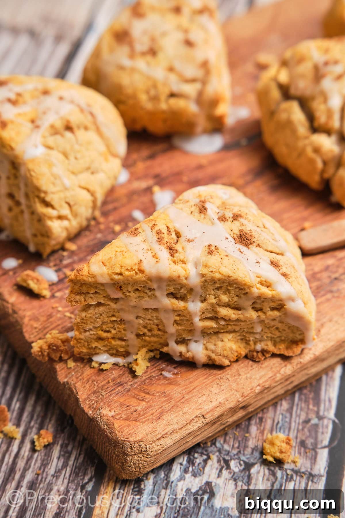 A triangle sweet potato scone with a white glaze on top, ready to be enjoyed.