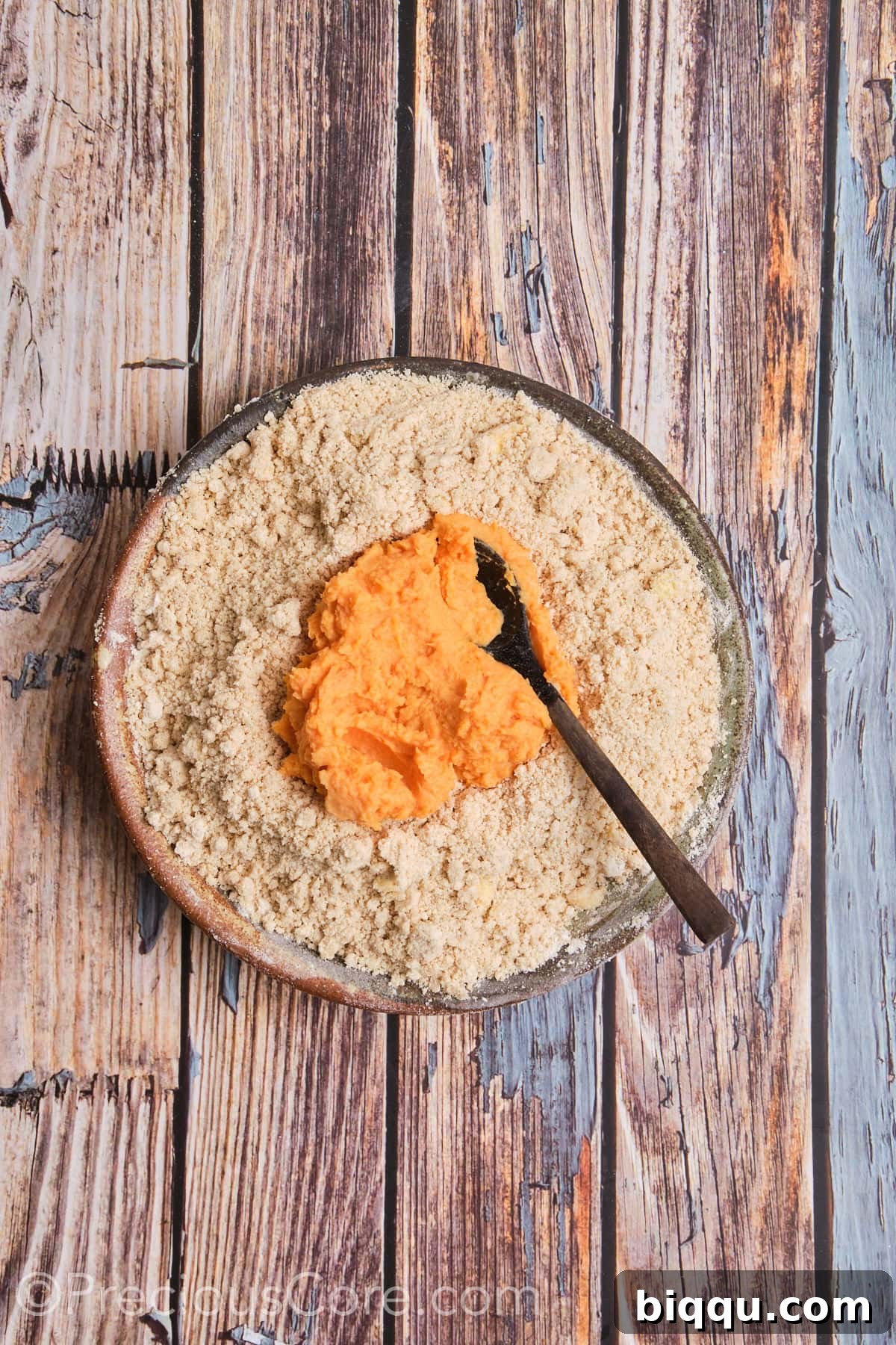 Adding sweet potato mixture to flour mixture in a bowl.