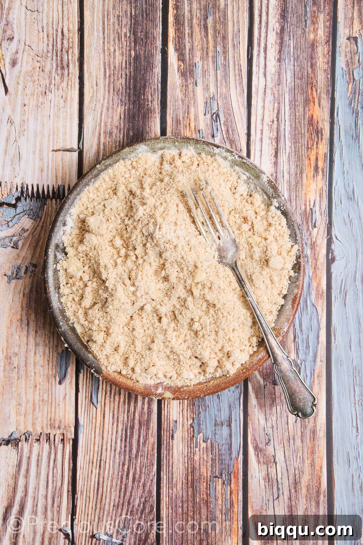 Flour and butter mixture after cutting, resembling coarse crumbs.