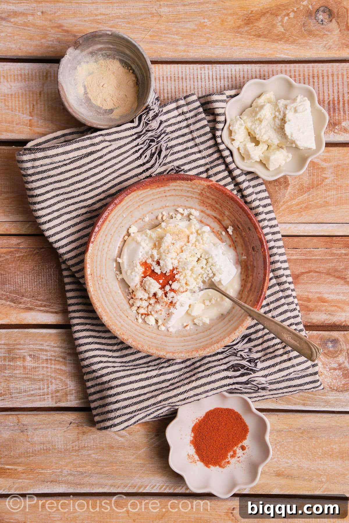 Combining mayonnaise, sour cream, spices, and cheese in a bowl for the casserole base.