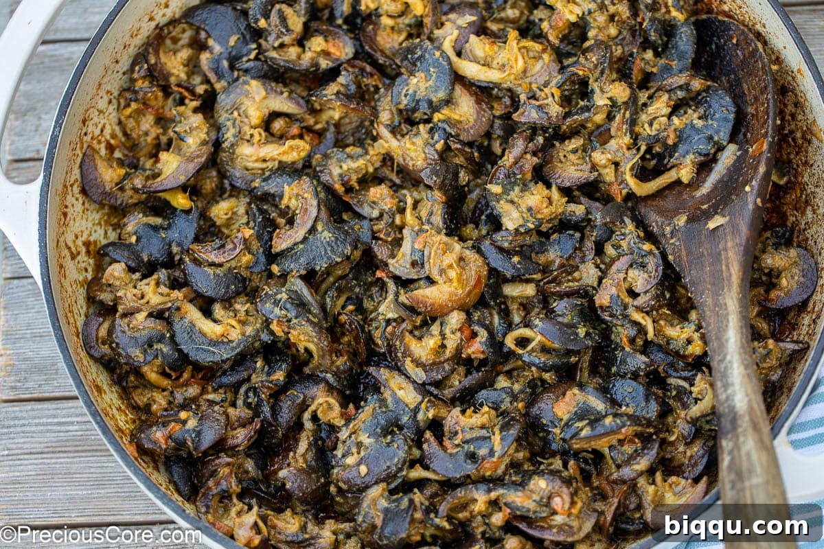 Cameroonian snails simmering in a pot, absorbing the rich flavors of the stew.