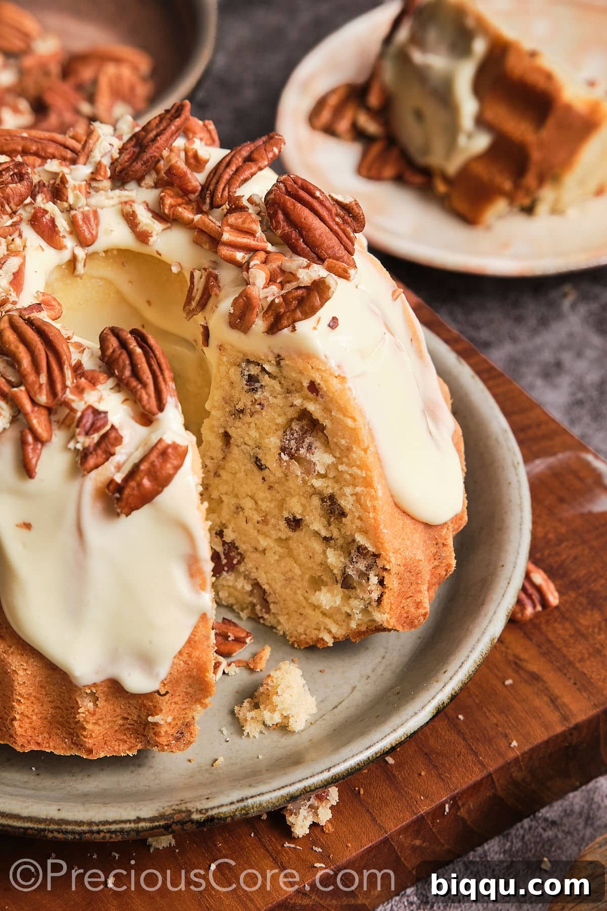 Close-up, overhead view of a slice of Butter Pecan Pound Cake, showing the moist crumb, pecans, and creamy frosting.