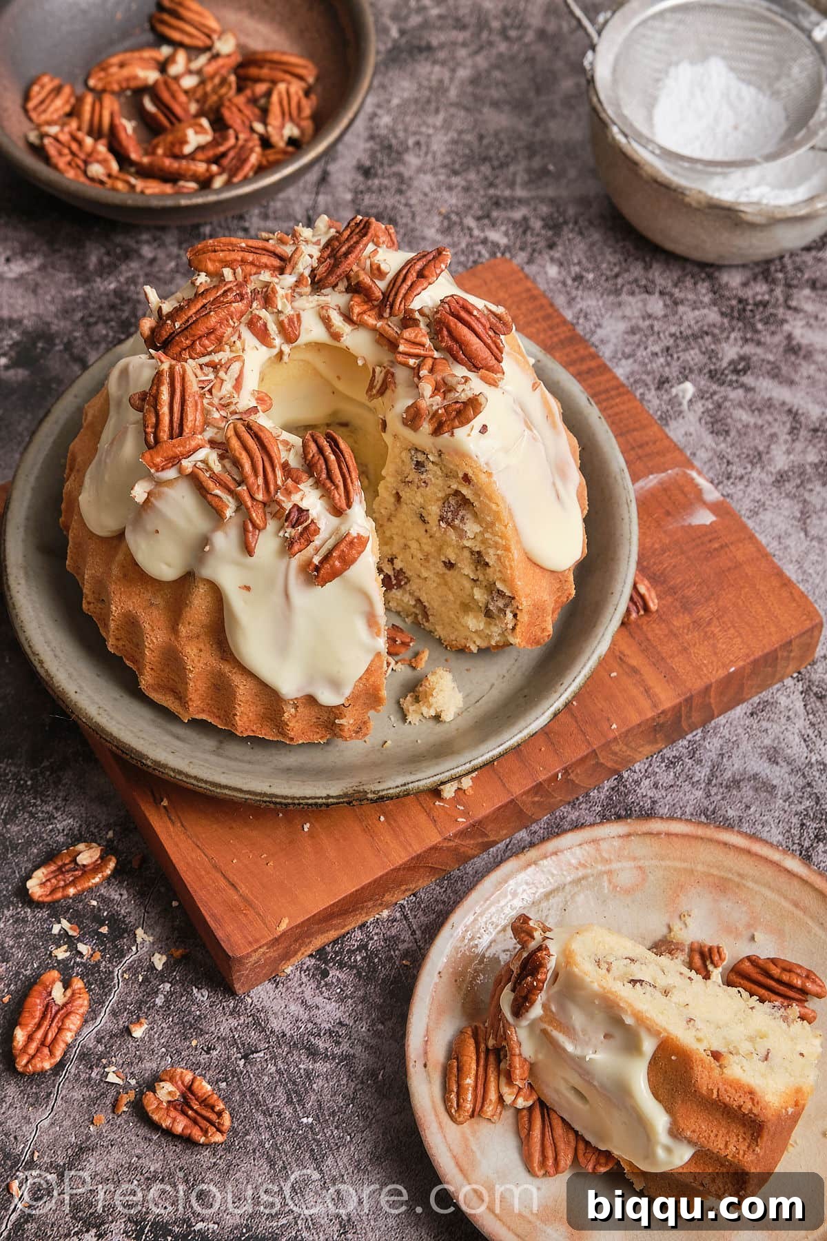 A luscious slice of Butter Pecan Pound Cake with cream cheese frosting, sitting on a plate.