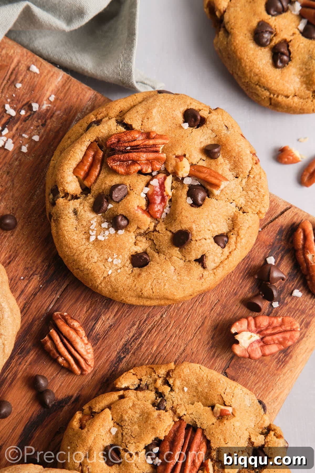 Brown Butter Pecan Bliss Cookies 2 Crispy and chewy brown butter pecan cookies on a chopping board.
