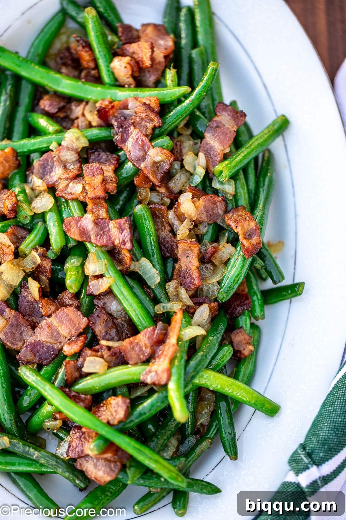 Bright colored green beans and bacon on tray.