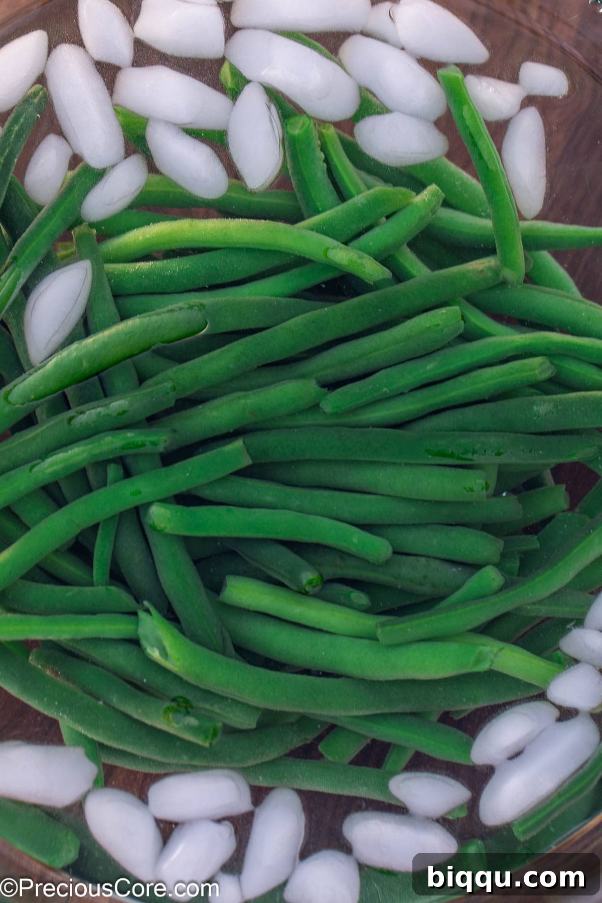 Blanched green beans in ice water.