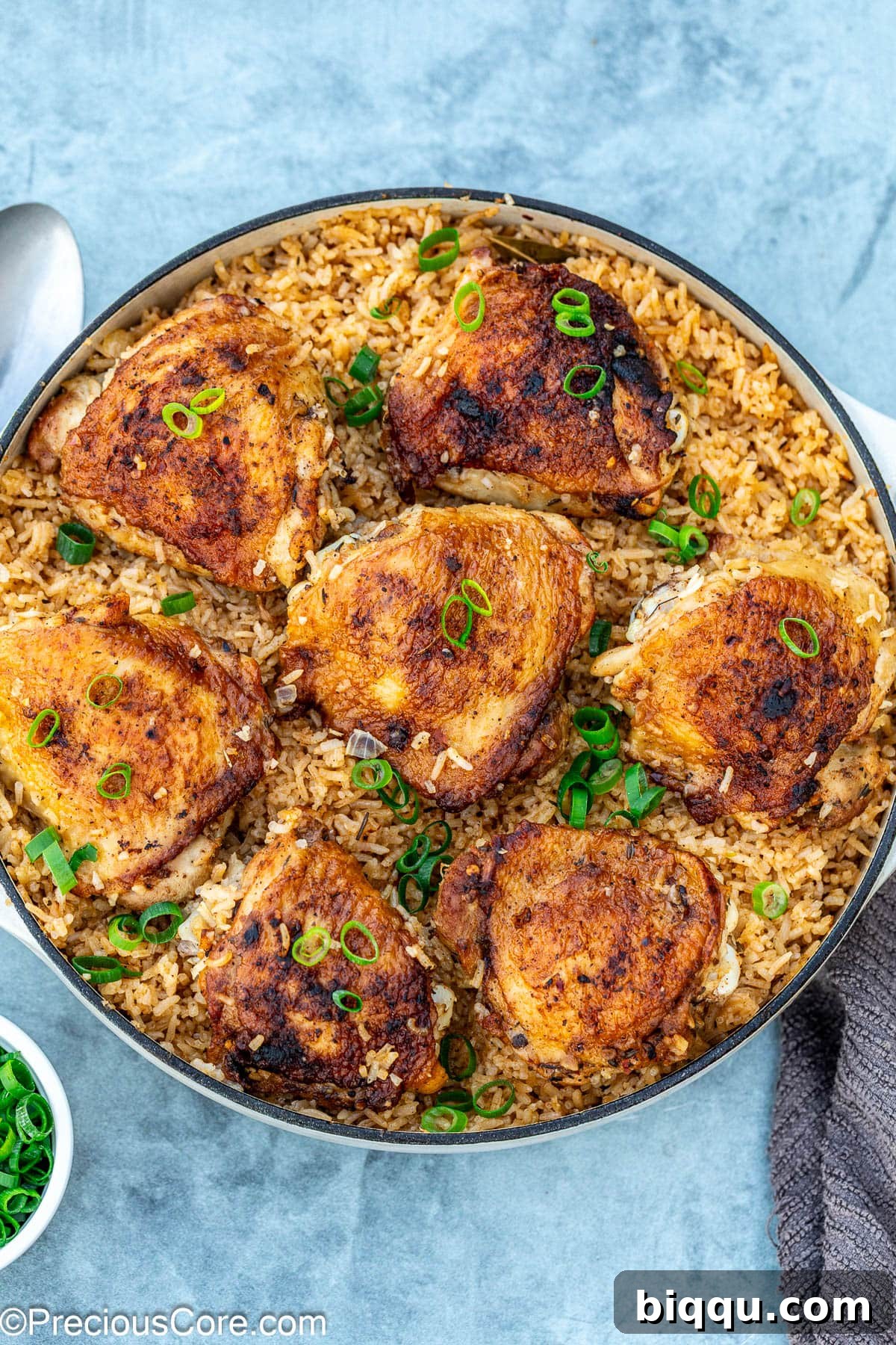 One pot chicken thighs and rice topped with freshly chopped green onions, ready to be served.