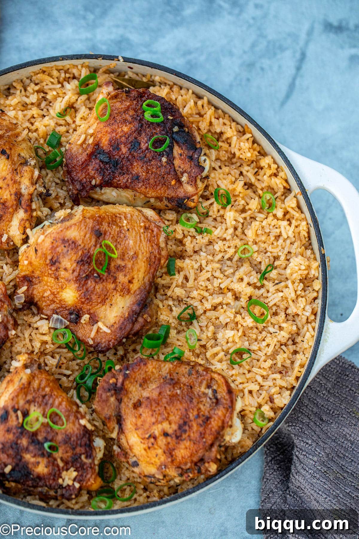 A beautiful closeup of the finished one pot chicken thighs and rice, highlighting its textures and garnishes.
