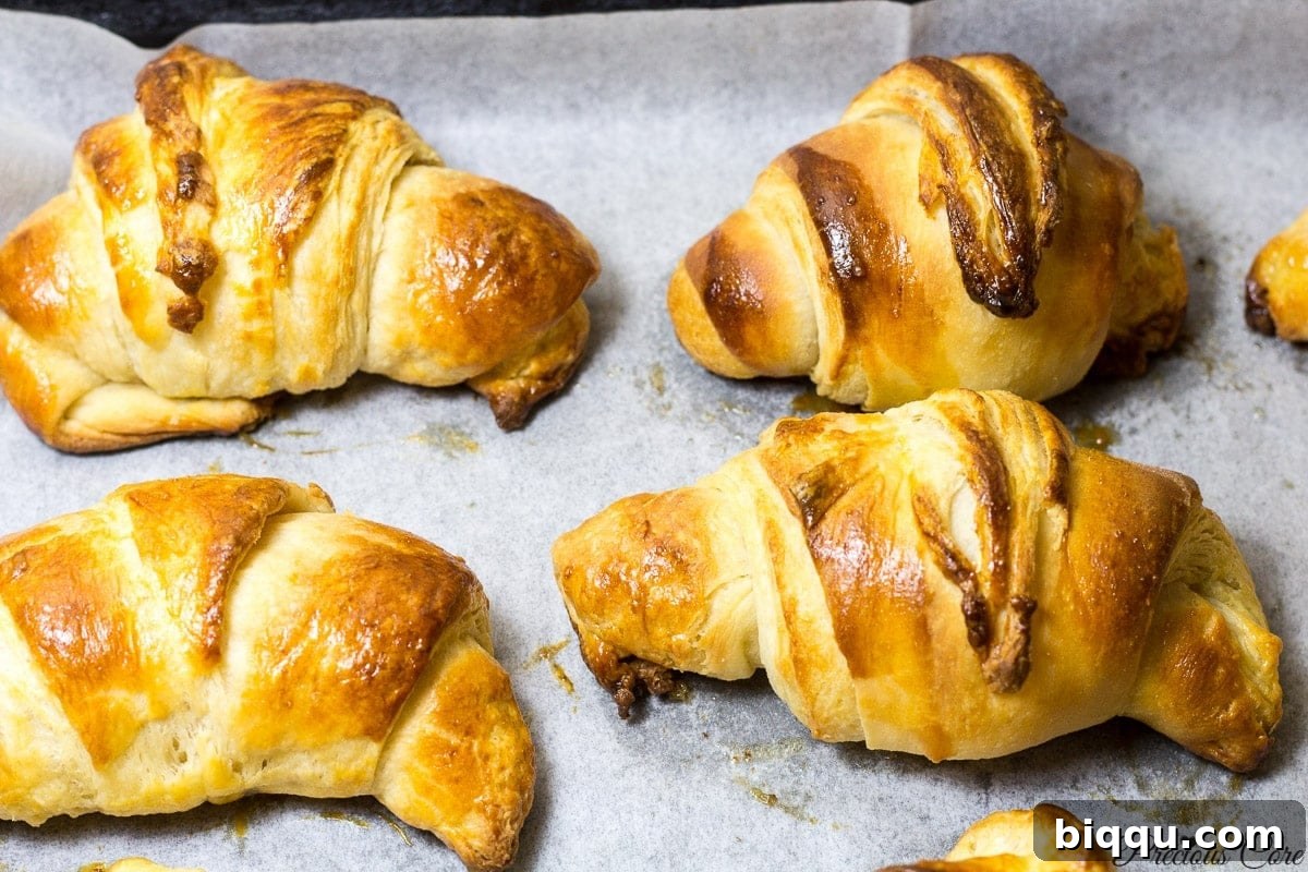 Homemade croissants on parchment paper, fresh from the oven.