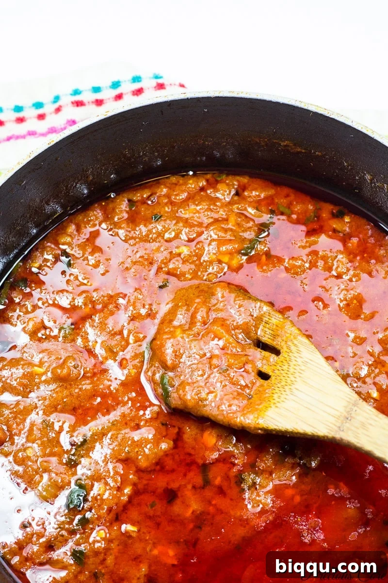 Tomato sauce simmering in a pan for the meatballs.