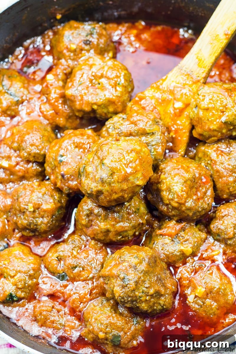 West African meatballs simmering in flavorful tomato sauce.