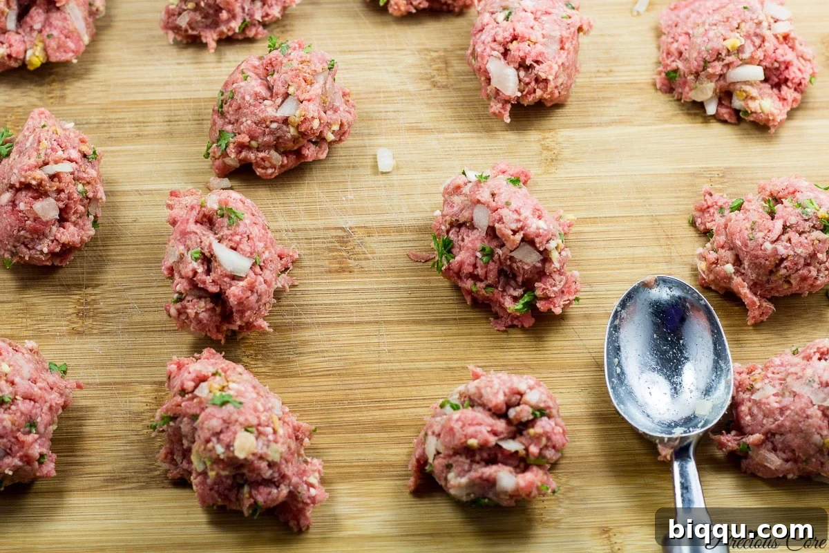 Using an ice cream scoop to portion out meatball mixture