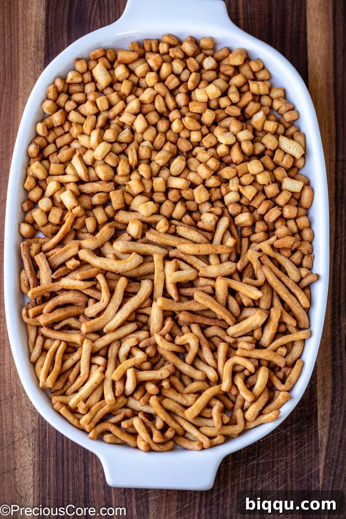 Crispy golden Chin Chin pieces perfectly arranged on a white serving tray, ready to be enjoyed as a delicious snack, highlighting their texture and appealing color.