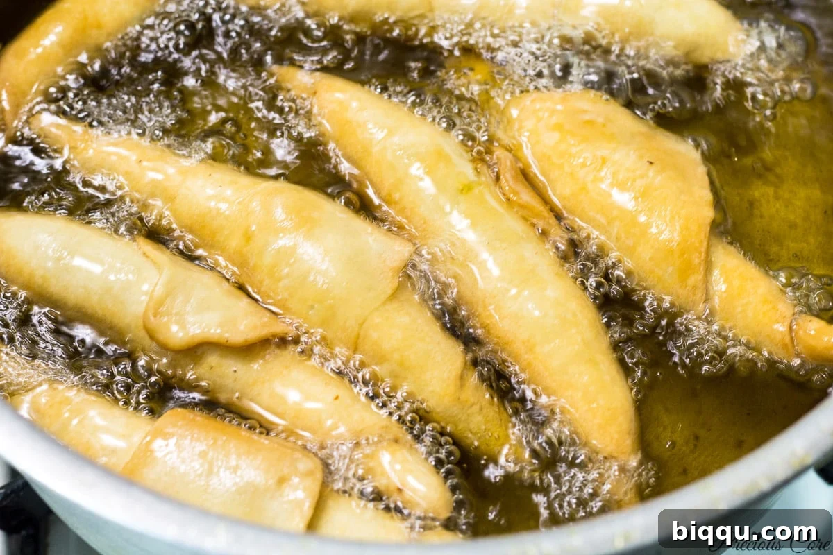 A batch of freshly fried, golden and crispy Cameroonian fish rolls, ready to be served