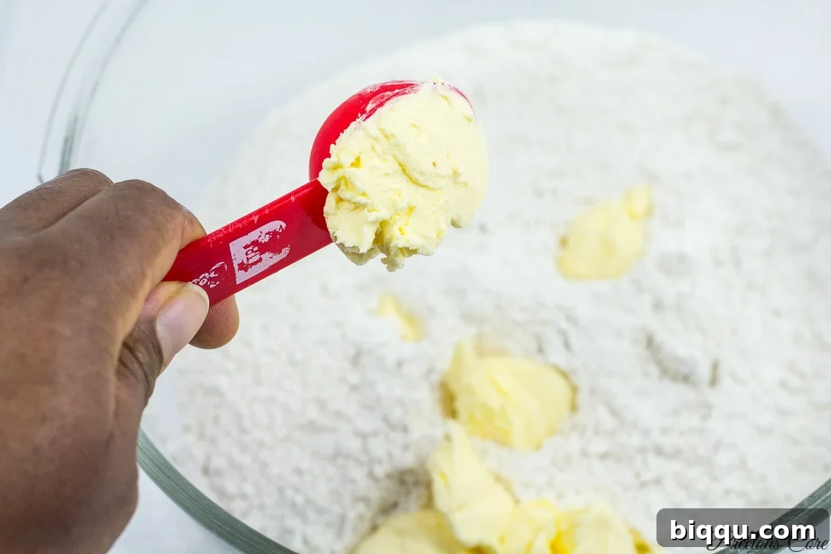 Adding softened butter or margarine to the flour for the Cameroonian fish rolls dough