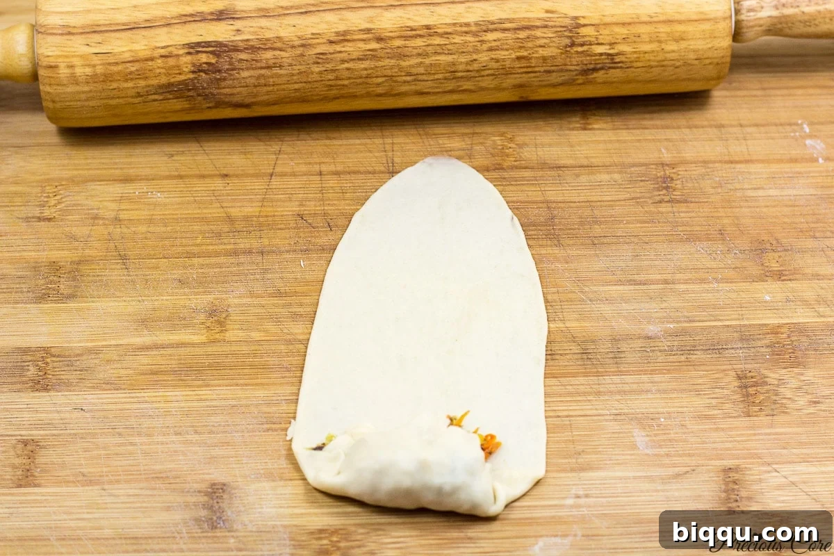 Illustrating the technique of folding and sealing the edges of Cameroonian fish rolls
