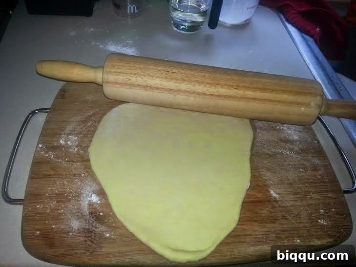 Dough piece rolled flat into an oval shape.