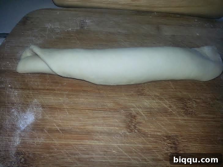 Dough being rolled up from one end to the other.