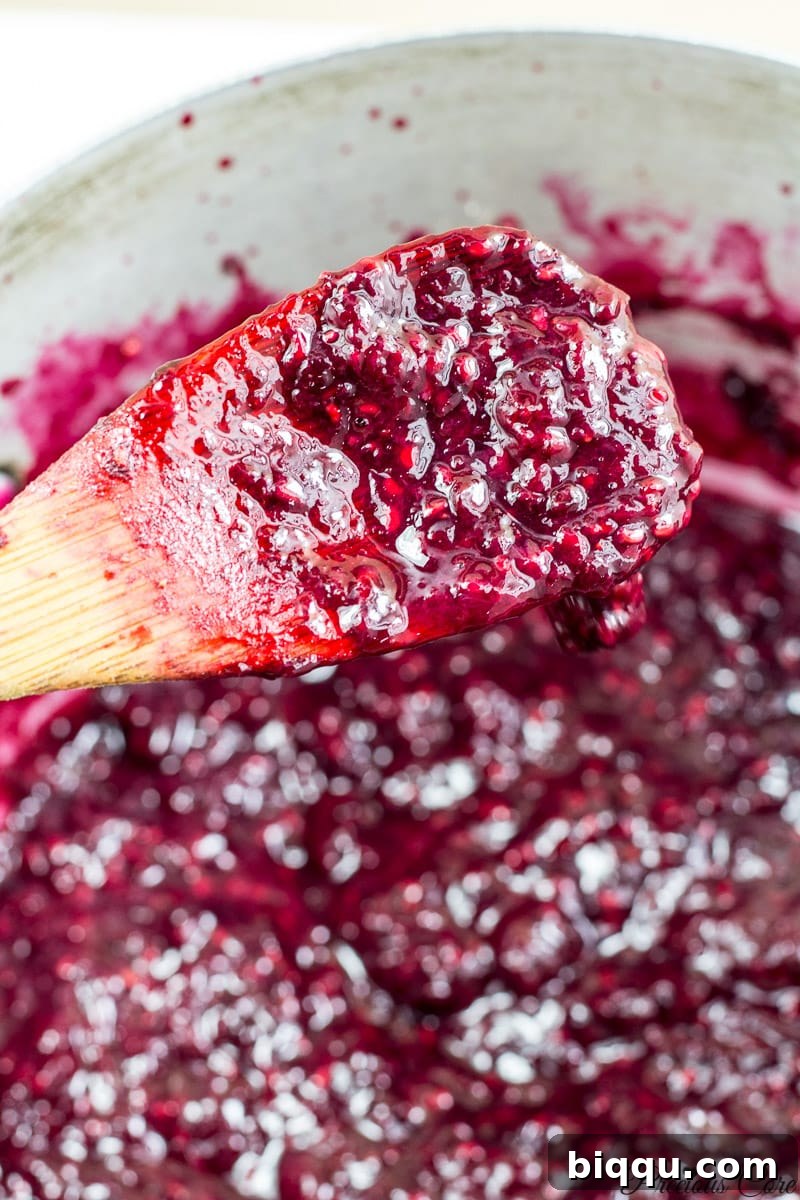 Close-up of the thick, rich, gel-like texture of the finished mixed berry jam.