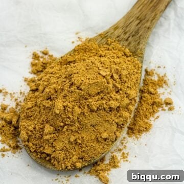 Homemade suya spice on a wooden spoon, indicating its delicious flavor.