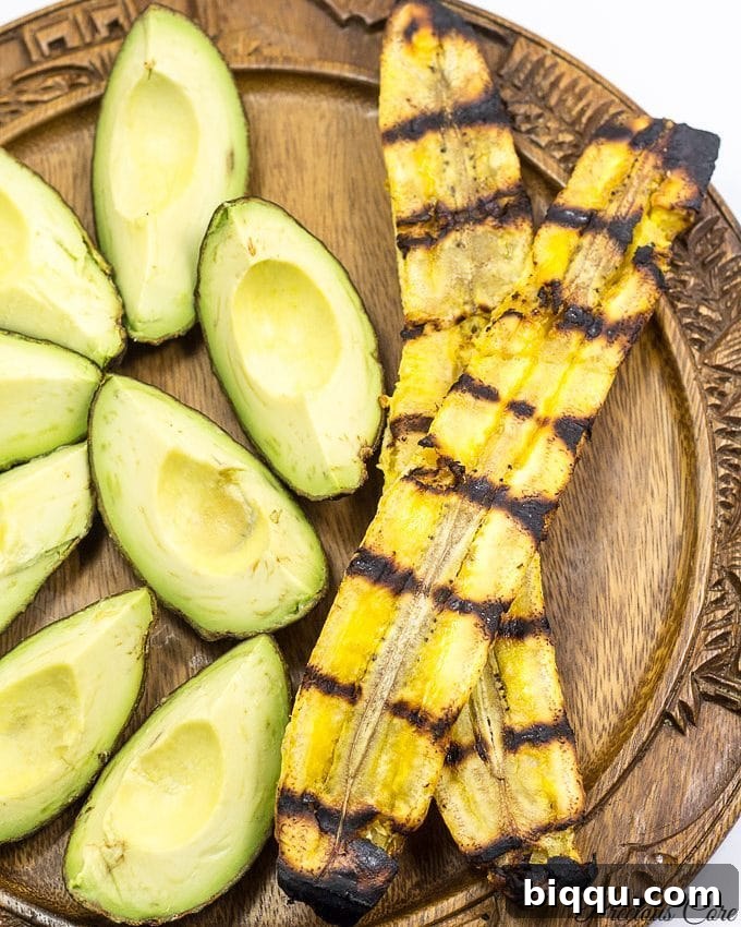 A plate featuring perfectly grilled plantains served with fresh avocado wedges.