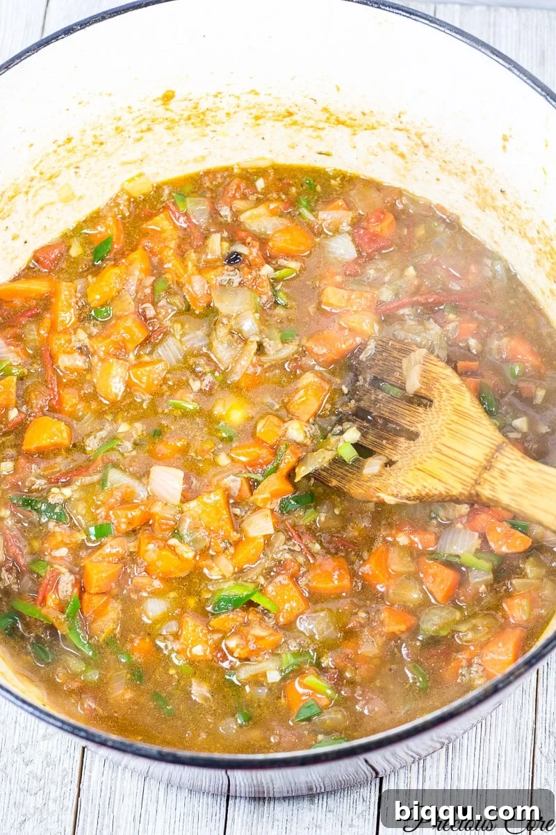 Rich tomato and onion stew base simmering in a pot, ready for beans