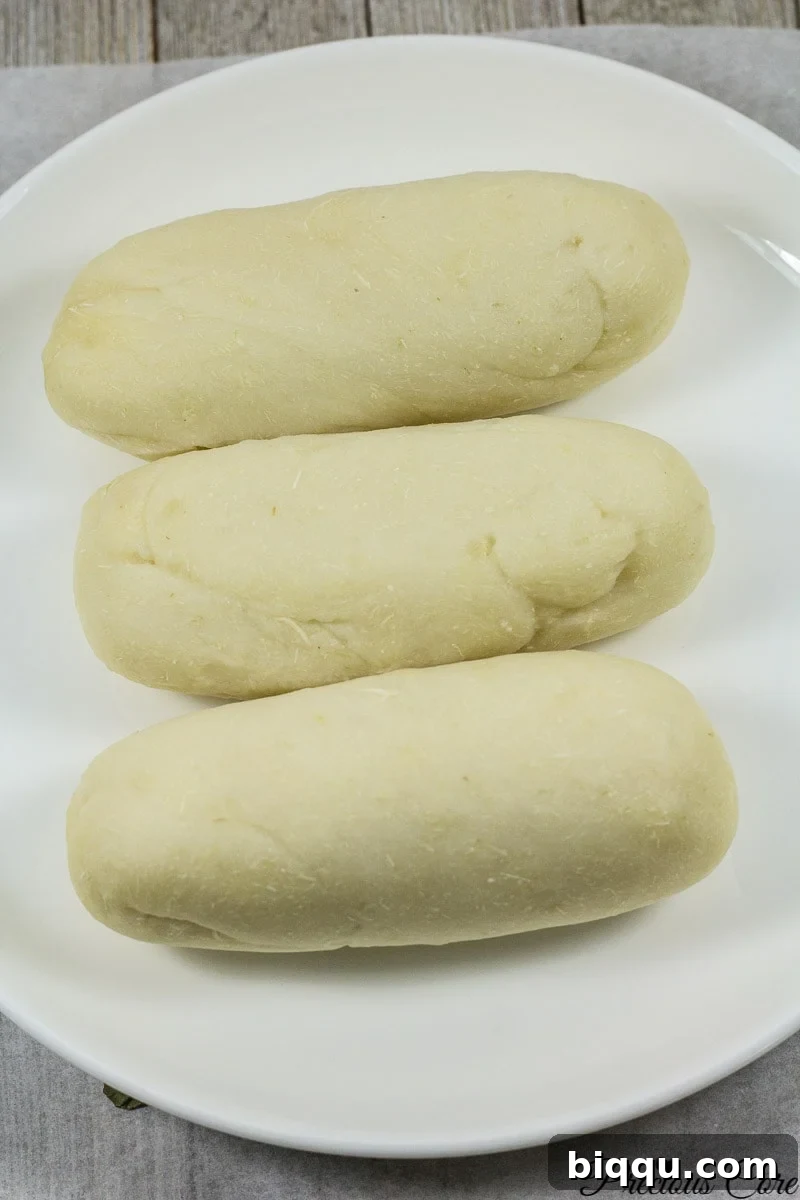 A close-up of peeled cassava roots soaking in water for fermentation.
