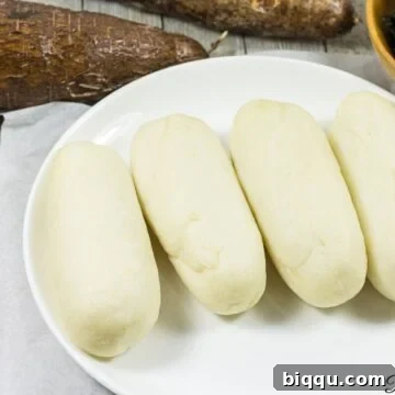 Water fufu or cassava fufu on a white plate.