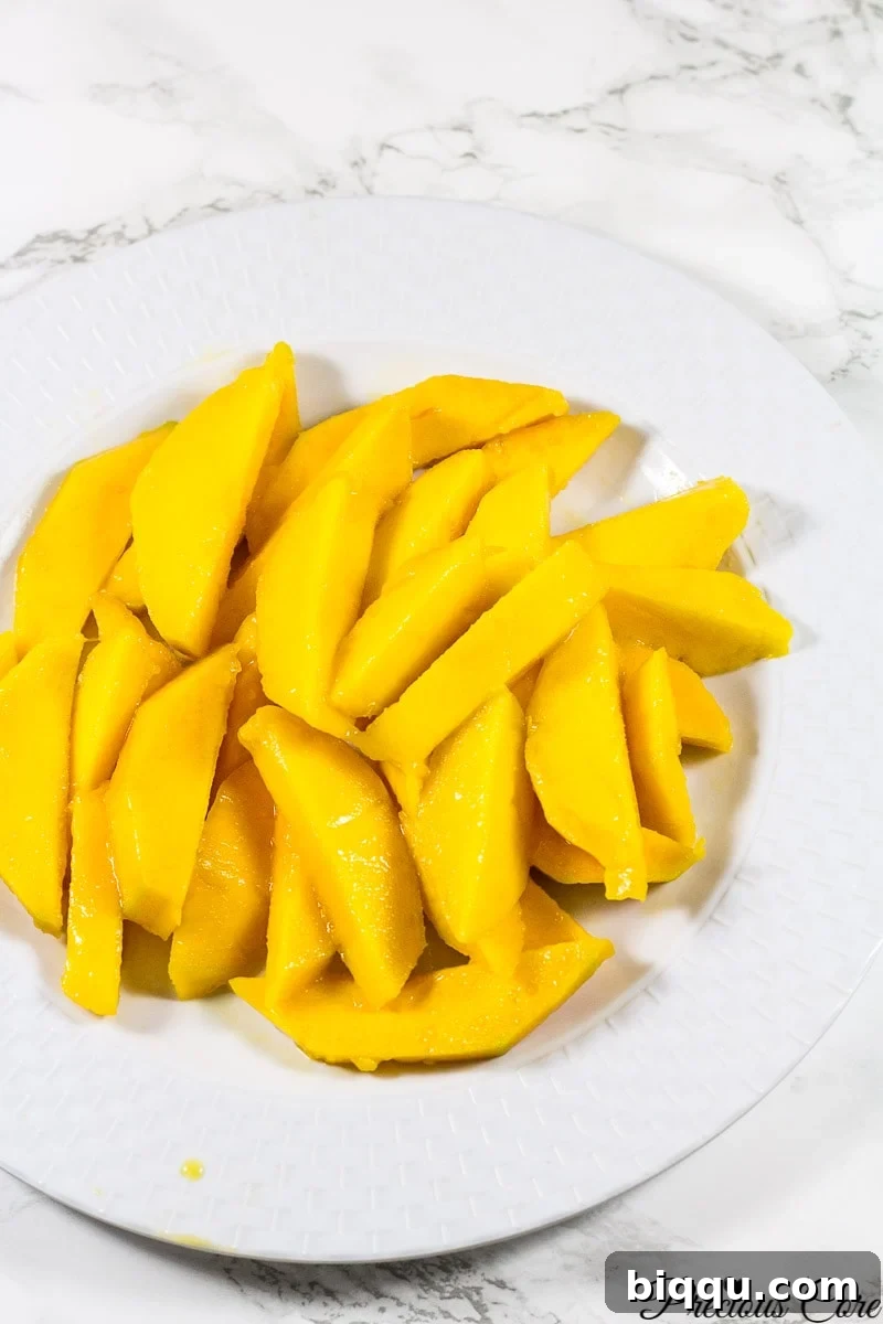 Close-up of perfectly sliced fresh mango on a white plate