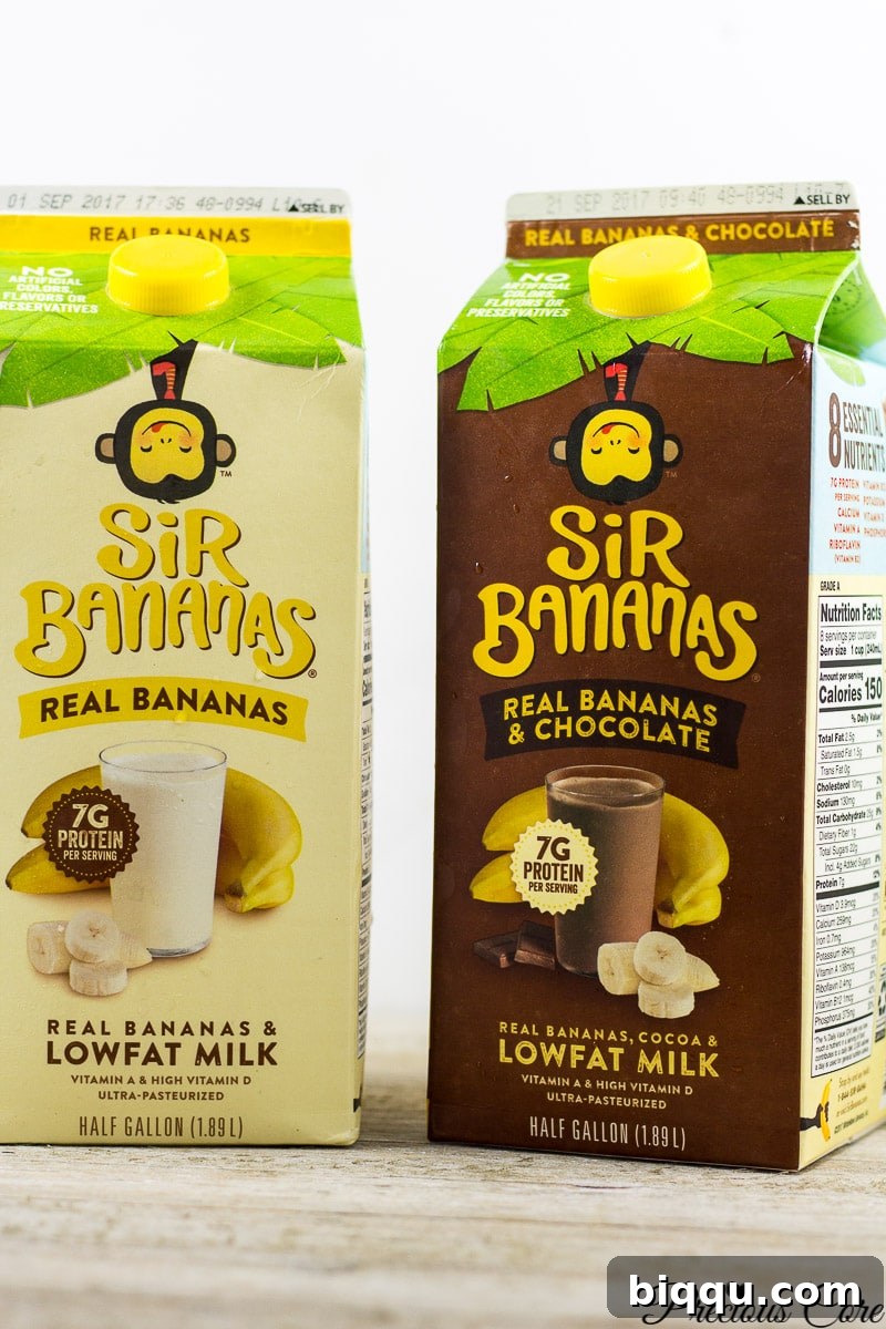 Cartons of Sir Bananas original banana milk and chocolate banana milk in a dairy aisle setting.