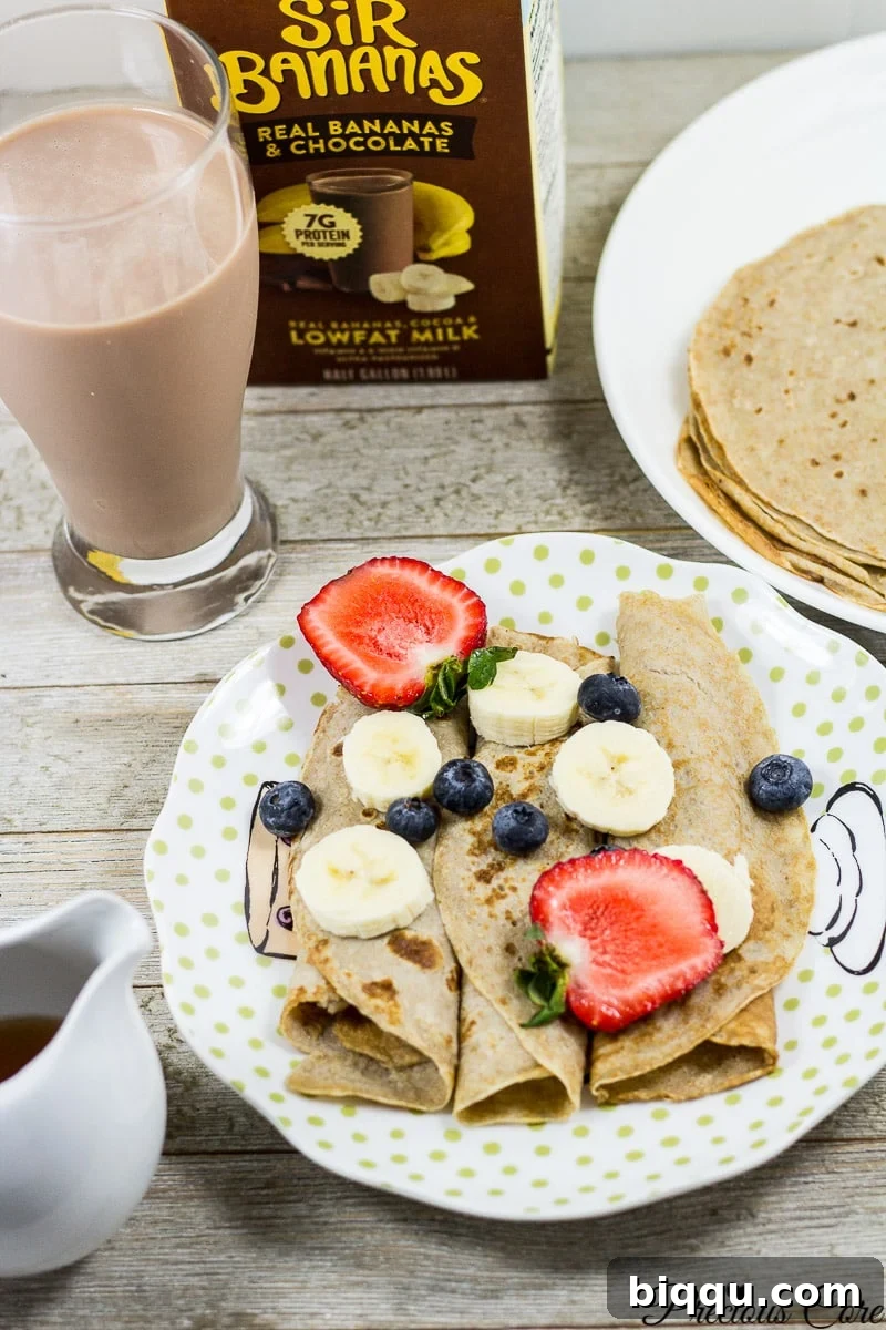 Healthy breakfast recipe: banana crepes served with fresh berries and a glass of Sir Bananas milk.