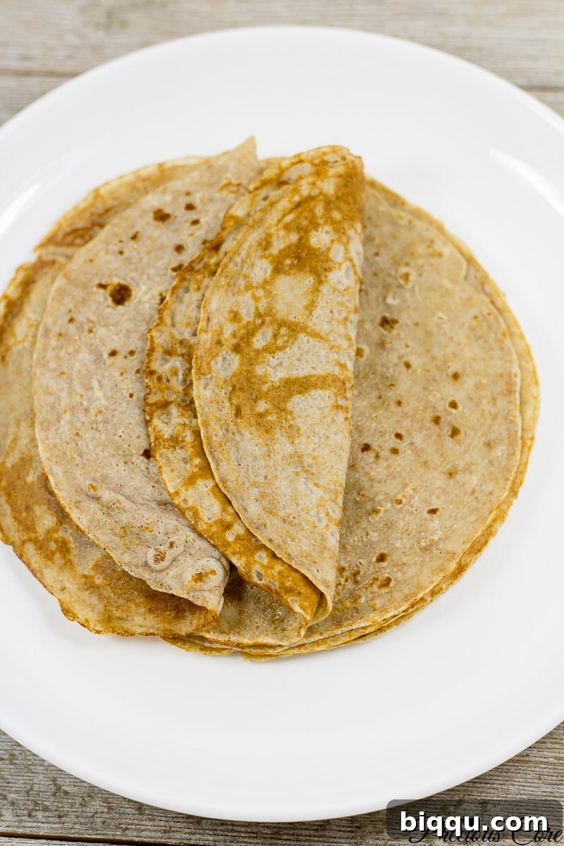 Healthy banana crepes recipe served beautifully with fresh fruit and a drizzle of syrup.