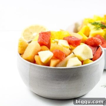 A beautifully presented bowl of authentic Cameroonian fruit salad, brimming with a mix of fresh, diced tropical fruits.