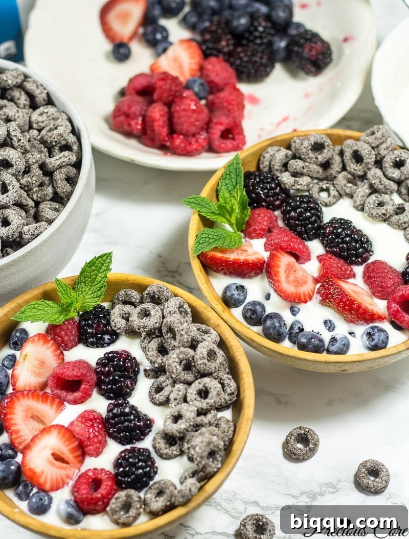 Two beautifully arranged mixed berry parfait bowls, ready to be enjoyed.