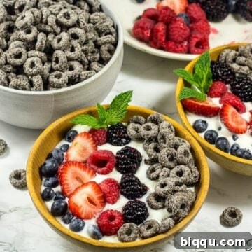 Two mixed berry parfait bowls, beautifully layered and ready to eat.
