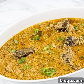 White, oblong bowl of Egusi stew.