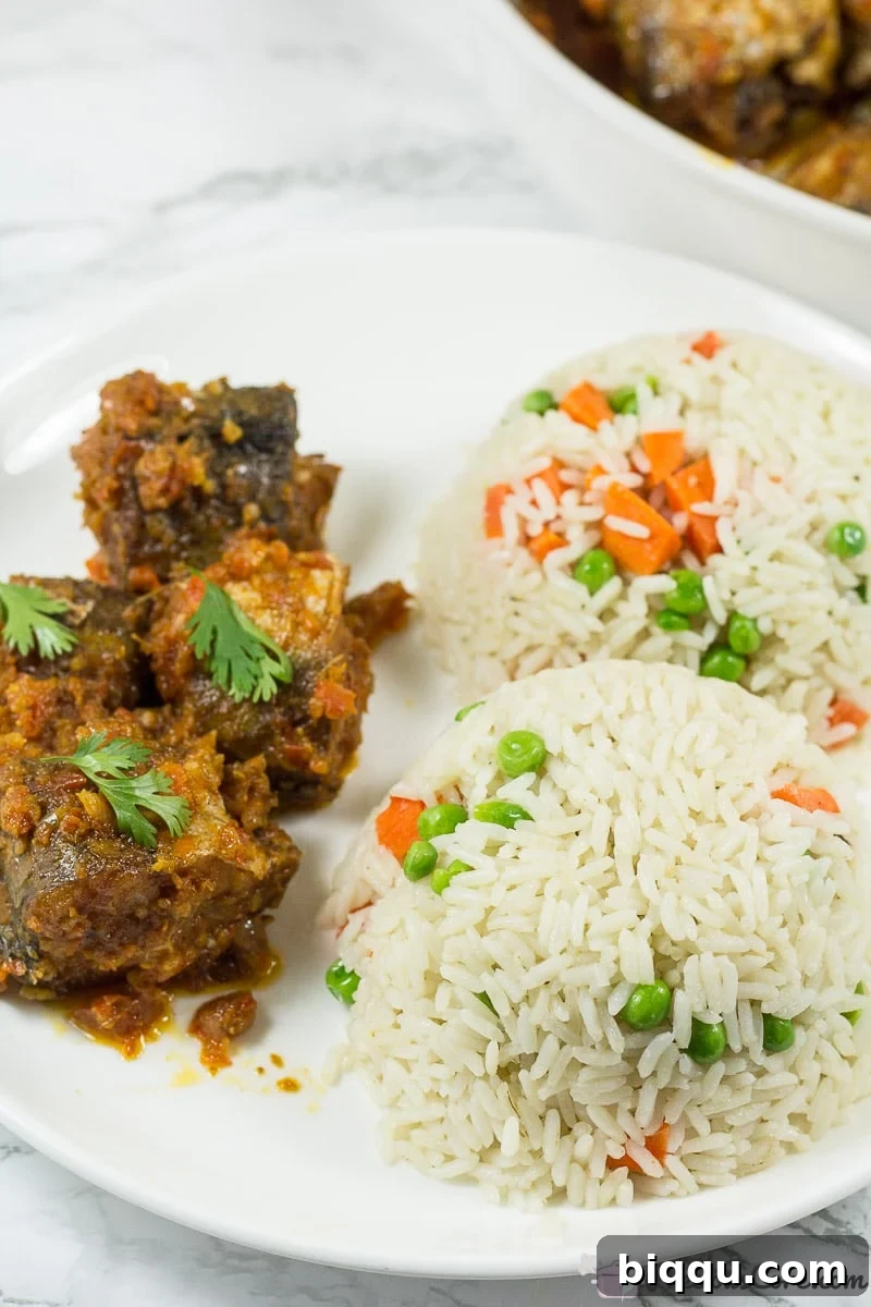 Nigerian Peppered Fish - Fish in Tomato Sauce served with coconut rice.