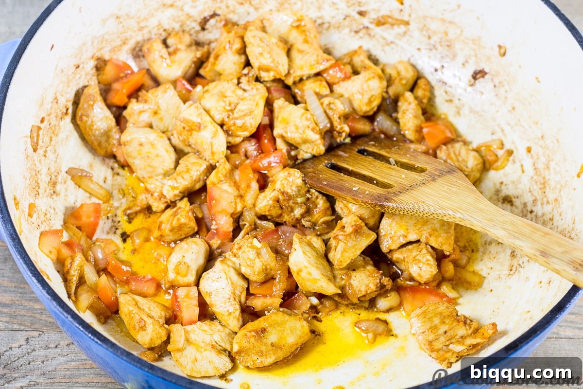 Macaroni and Chicken dinner recipe step 3: adding onions, garlic, and tomatoes to chicken