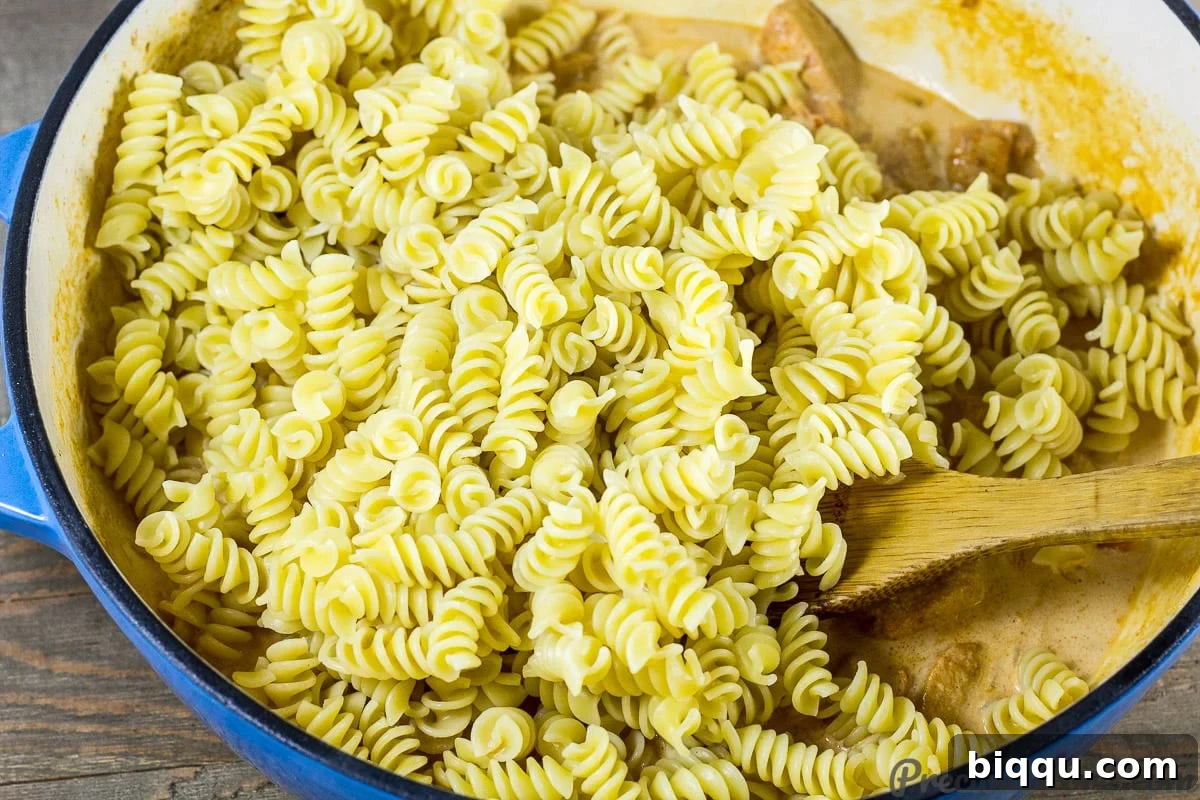 Macaroni and Chicken dinner recipe step 6: mixing macaroni into the creamy sauce